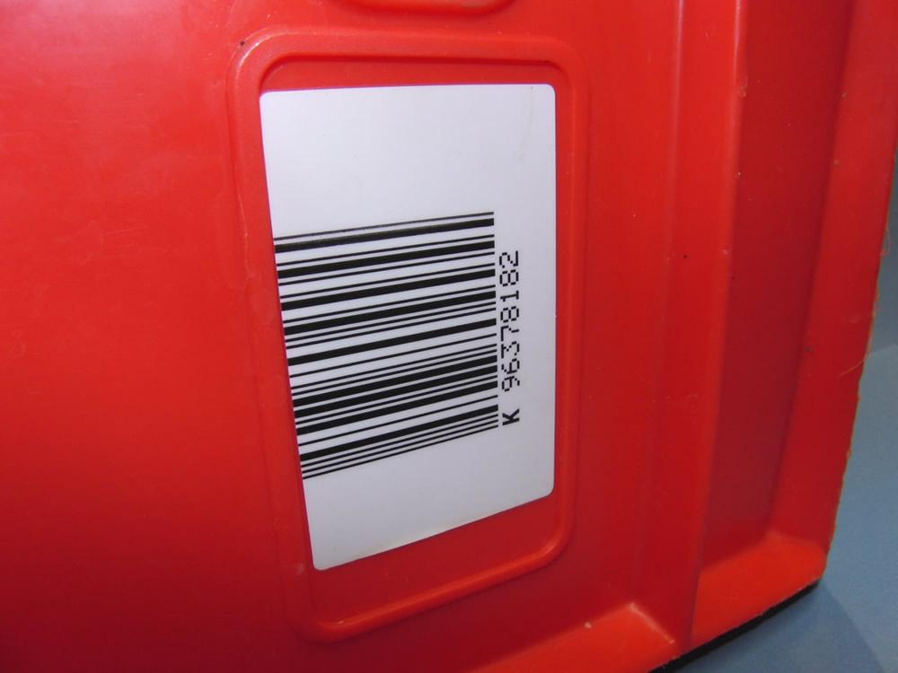 Barcodeetikett zur Behälterkennzeichnung auf einer roten Plastikkiste