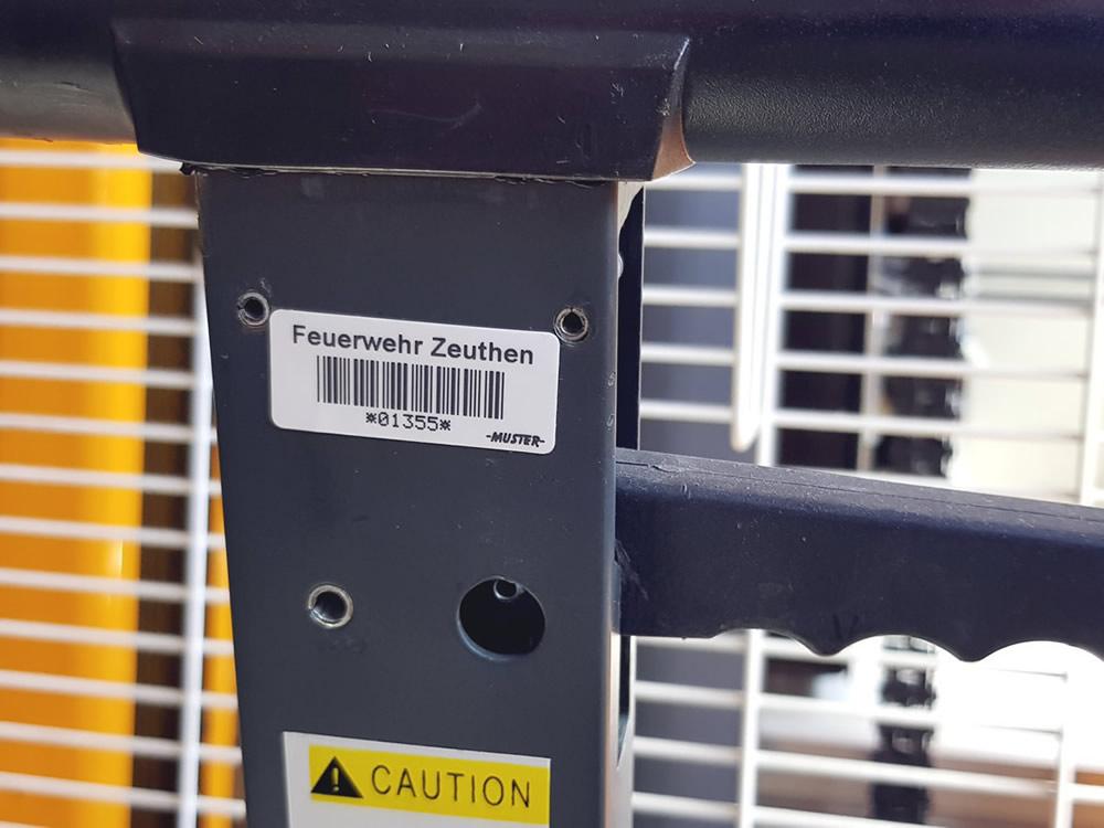 Inventarschild mit Barcode und Nummer auf einem Gerät der Feuerwehr